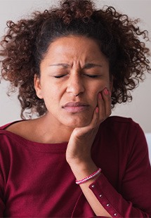 Woman with toothache sitting on couch at home